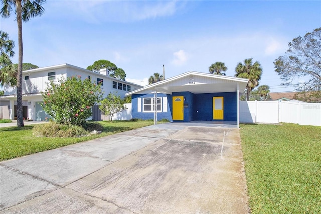 view of front facade featuring a carport, a front yard, driveway, and fence