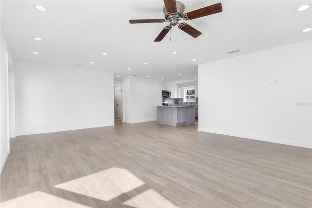 unfurnished living room featuring light wood-style floors, baseboards, visible vents, and recessed lighting