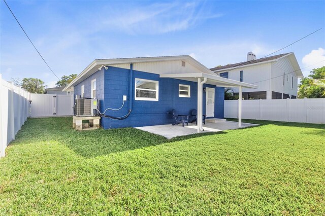 rear view of property featuring a fenced backyard, a lawn, a patio, and central air condition unit