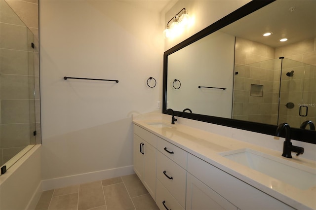 bathroom with a stall shower, a sink, baseboards, and tile patterned floors