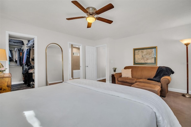 carpeted bedroom with a closet, a spacious closet, a ceiling fan, connected bathroom, and baseboards