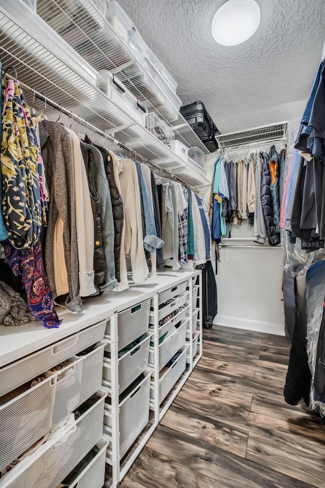 walk in closet with wood finished floors