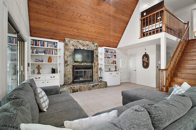 tiled living room with wooden ceiling, stairway, built in shelves, high vaulted ceiling, and a fireplace