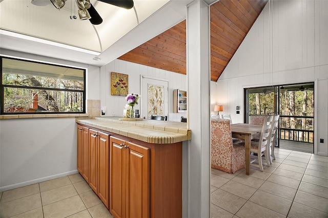 kitchen featuring light tile patterned floors, plenty of natural light, tile counters, and brown cabinetry