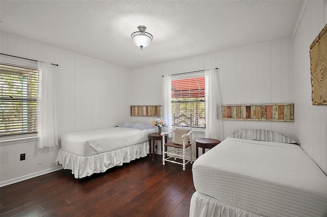 bedroom featuring wood-type flooring, baseboards, and a textured ceiling