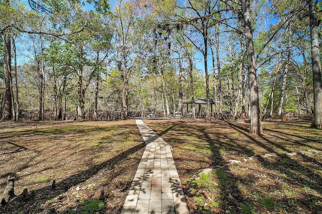 view of yard featuring a wooded view and a gazebo