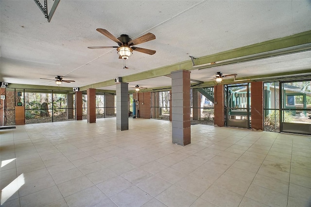 spare room featuring tile patterned flooring, decorative columns, and a textured ceiling