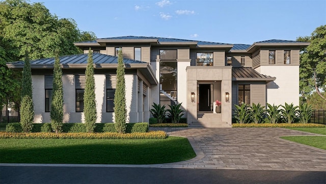 prairie-style home featuring a standing seam roof, brick siding, and metal roof