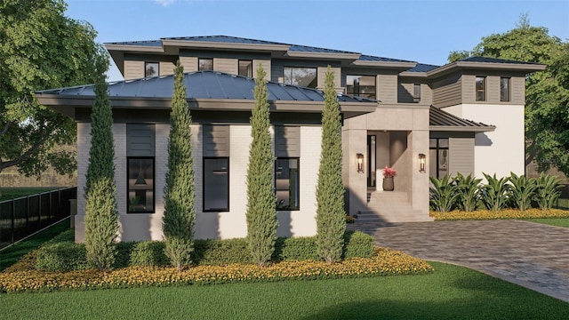 prairie-style house featuring a standing seam roof, metal roof, a front lawn, and fence