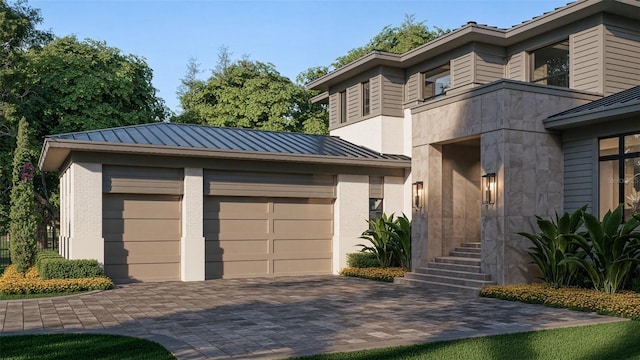 view of front of home with a standing seam roof, metal roof, decorative driveway, and brick siding