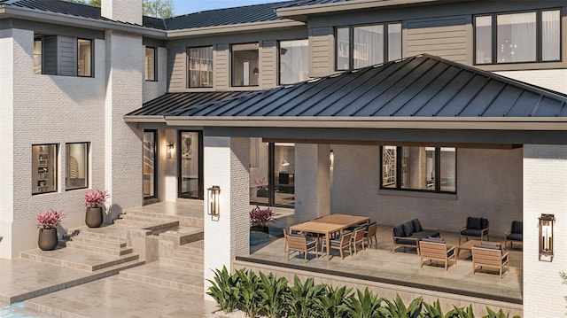 rear view of house with an outdoor hangout area, metal roof, brick siding, and a standing seam roof