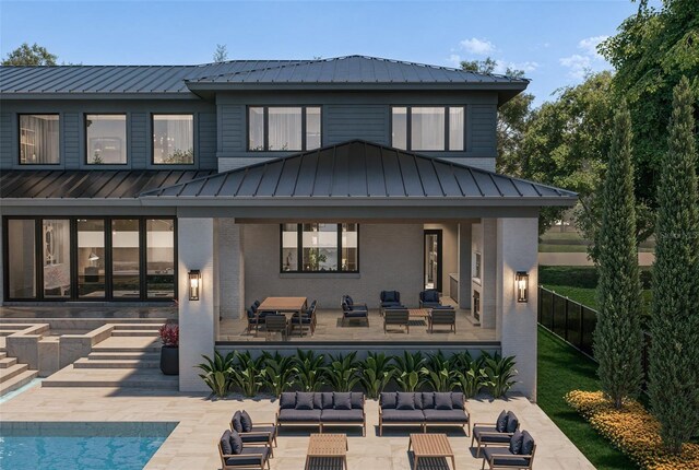 back of house featuring a patio, metal roof, a standing seam roof, outdoor lounge area, and brick siding