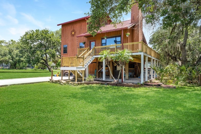 back of property with a deck, stairway, and a lawn