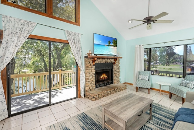 living area featuring a ceiling fan, baseboards, high vaulted ceiling, a fireplace, and tile patterned flooring