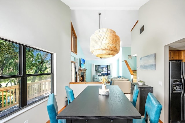dining space featuring visible vents and a high ceiling