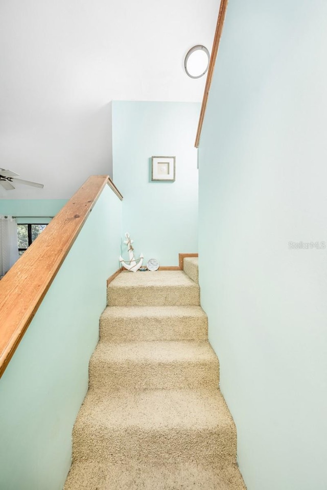 staircase featuring a ceiling fan