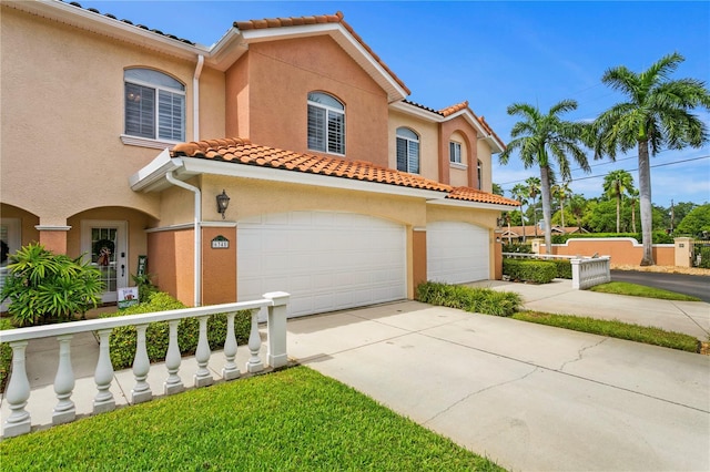 mediterranean / spanish-style house with driveway, an attached garage, and stucco siding