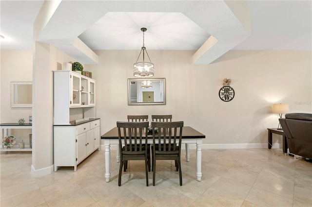 dining area with light tile patterned floors, baseboards, and an inviting chandelier