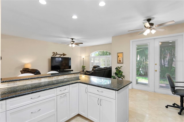 kitchen with french doors, recessed lighting, open floor plan, white cabinetry, and dark stone counters