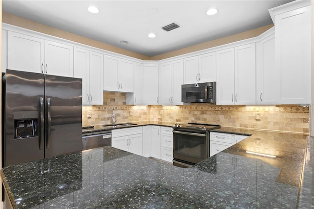 kitchen featuring stainless steel appliances, a sink, visible vents, white cabinets, and backsplash