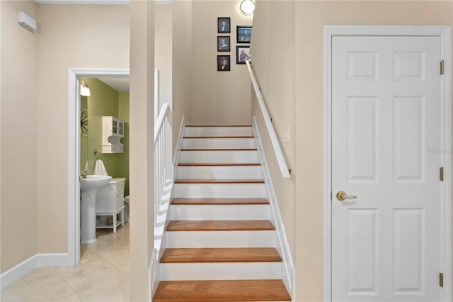 stairs with baseboards and tile patterned floors