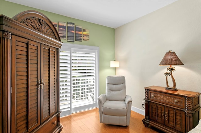 living area featuring baseboards and wood finished floors