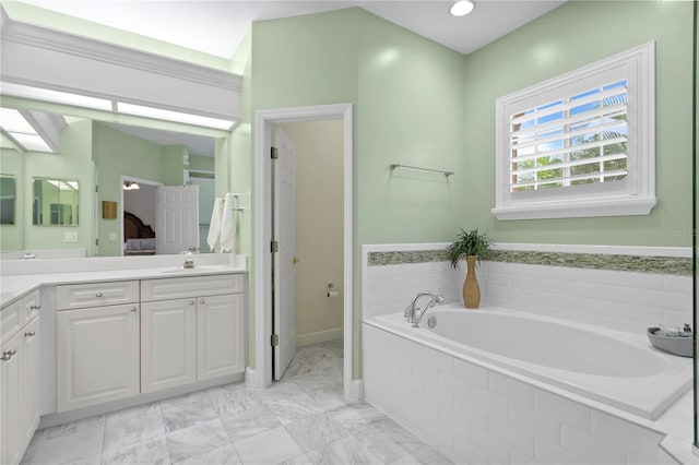 full bathroom with marble finish floor, a garden tub, vanity, and ensuite bath