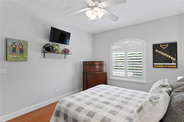 bedroom with a ceiling fan, baseboards, and wood finished floors