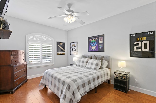 bedroom featuring ceiling fan, baseboards, and wood finished floors