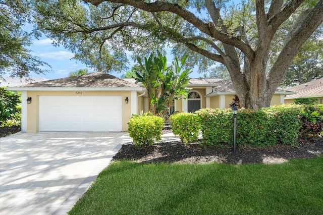 ranch-style home featuring a garage, driveway, and stucco siding