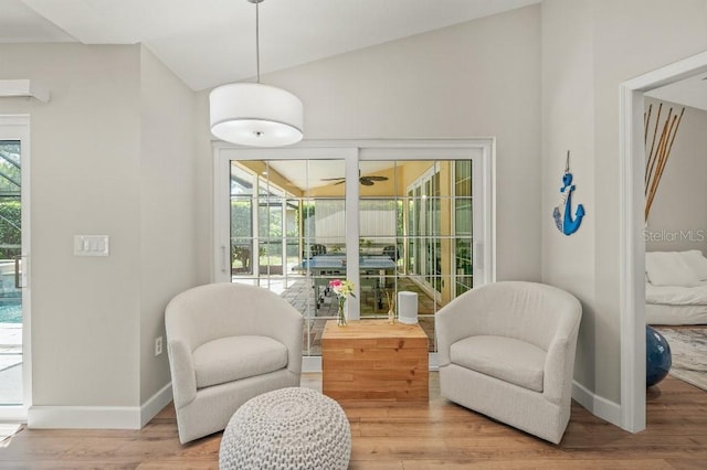 living area with ceiling fan, wood finished floors, a sunroom, and baseboards