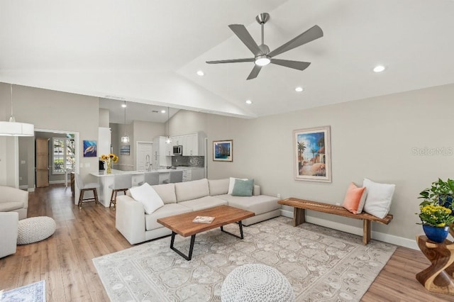 living room with baseboards, ceiling fan, light wood-type flooring, high vaulted ceiling, and recessed lighting