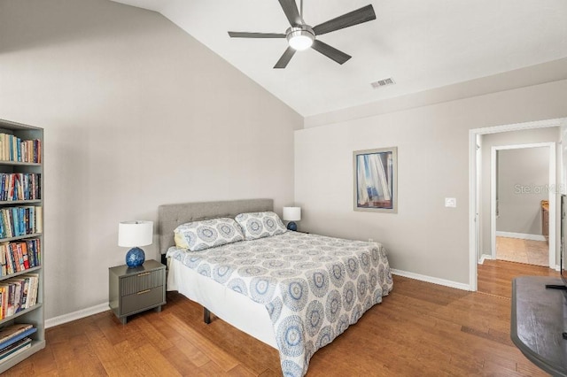 bedroom featuring lofted ceiling, baseboards, visible vents, and wood finished floors