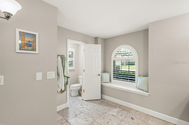 bathroom with toilet and baseboards