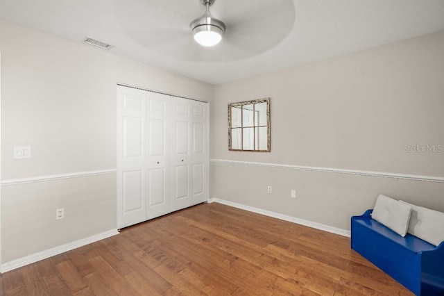 unfurnished room featuring baseboards, visible vents, and wood finished floors