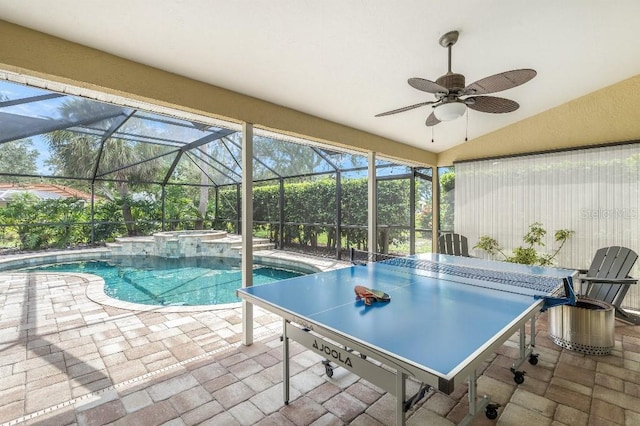 view of swimming pool featuring a ceiling fan, a patio, a lanai, a pool with connected hot tub, and outdoor dining space