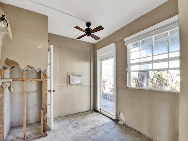 spare room with a wall unit AC and a ceiling fan