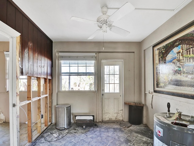 interior space featuring electric water heater and a ceiling fan