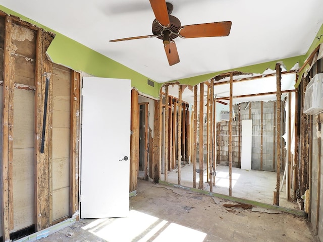 misc room with a wall mounted AC and ceiling fan