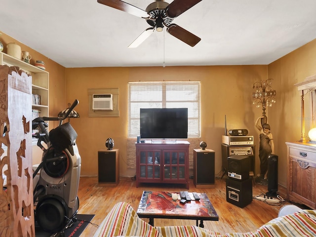 living room featuring a ceiling fan, wood finished floors, and a wall mounted AC