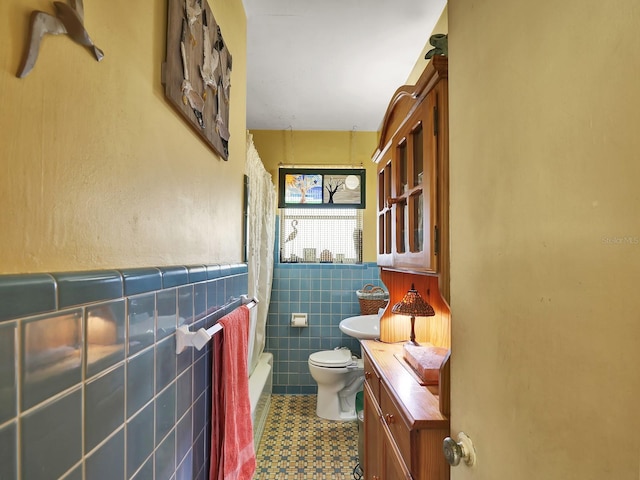 full bathroom featuring vanity, tub / shower combination, wainscoting, tile walls, and toilet