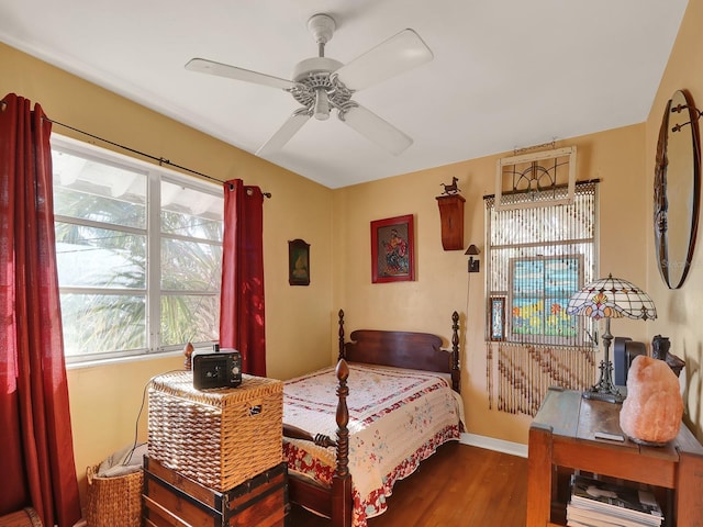 bedroom featuring ceiling fan, baseboards, and wood finished floors