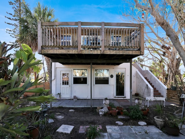 back of house with a deck, a patio, stairway, and stucco siding