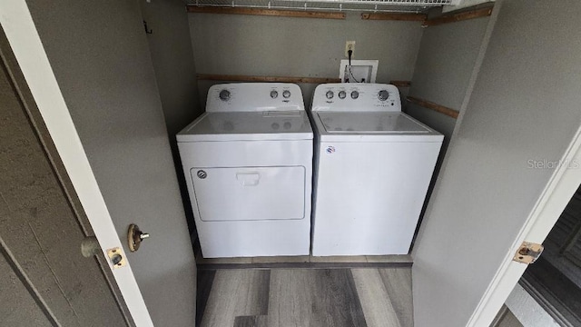 washroom featuring washer and dryer, laundry area, and wood finished floors