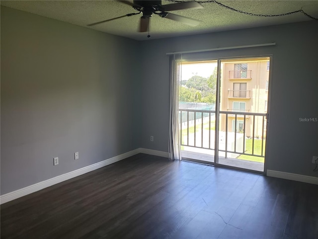 spare room featuring a ceiling fan, dark wood-style flooring, a textured ceiling, and baseboards