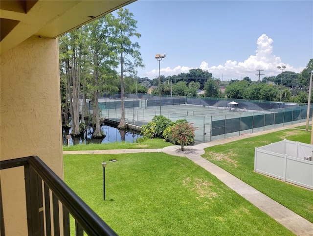 exterior space with a water view, fence, and a lawn