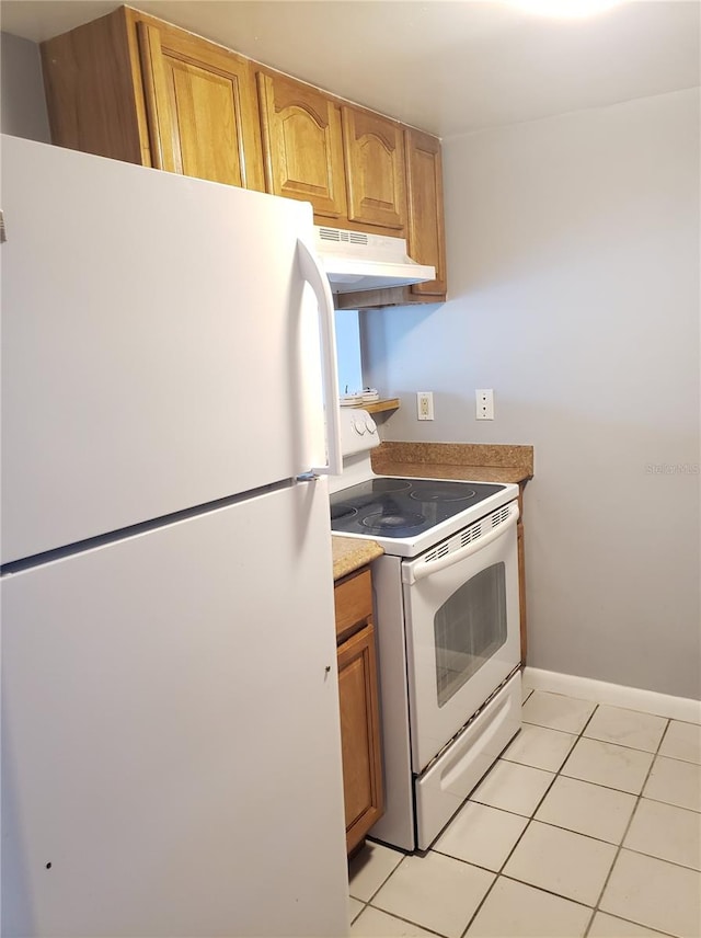 kitchen with white appliances, baseboards, light countertops, under cabinet range hood, and light tile patterned flooring