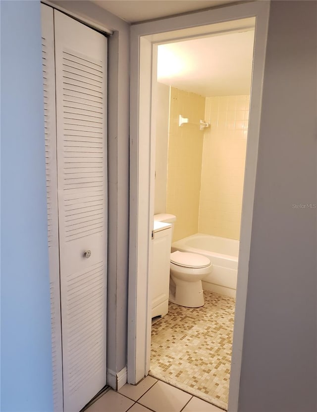 bathroom featuring toilet, shower / washtub combination, a closet, and tile patterned floors