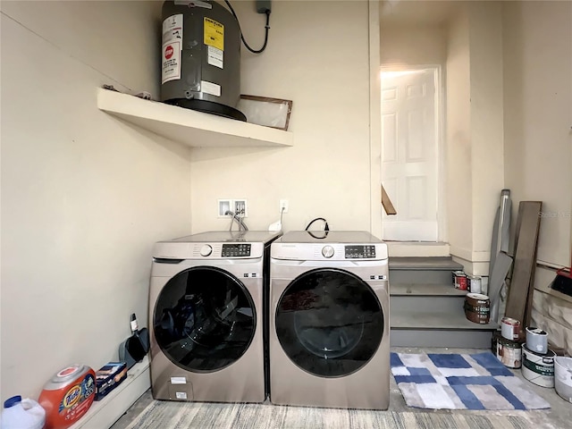 washroom with laundry area, water heater, and washer and clothes dryer