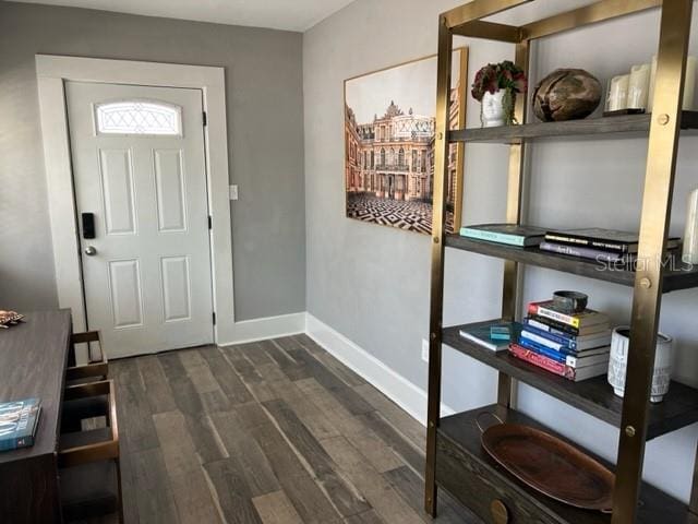 entryway with dark wood finished floors and baseboards